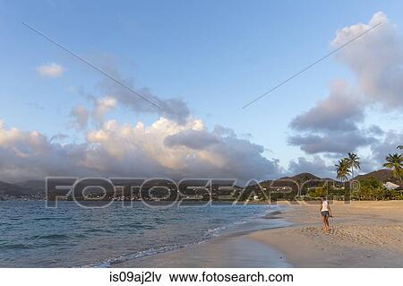 Rear view of mid adult woman strolling on beach, Spice Island beach resort, Grenada, Caribbean View Large Photo Image Stock Photo - Rear view of mid adult woman strolling on beach, Spice Island beach resort, Grenada, Caribbean. Fotosearch
