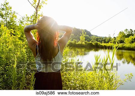 Rear view of young woman with hands in hair in sunlight, Delaware Canal State Park, New Hope, Pennsylvania, USA View Large Photo Image Stock Photograph - Rear view of young woman with hands in hair in sunlight, Delaware Canal State Park, New Hope, Pennsylvania, USA. Fotosearch