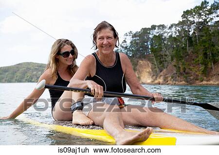 Senior woman and daughter paddleboarding at sea View Large Photo Image Stock Image - Senior woman and daughter paddleboarding at sea. Fotosearch