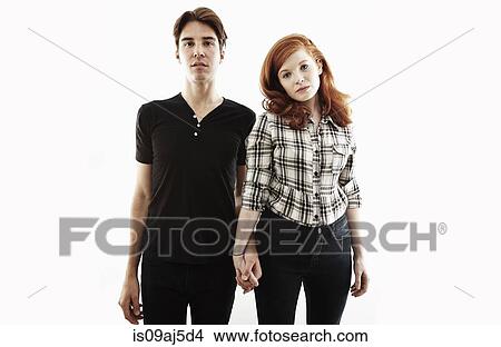 Studio portrait of bored looking young couple View Large Photo Image Picture - Studio portrait of bored looking young couple. Fotosearch