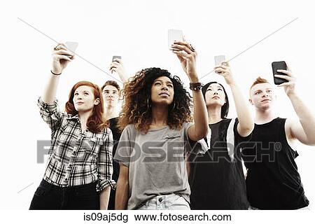 Studio portrait of five young adults taking selfies on smartphones View Large Photo Image Stock Image - Studio portrait of five young adults taking selfies on smartphones. Fotosearch