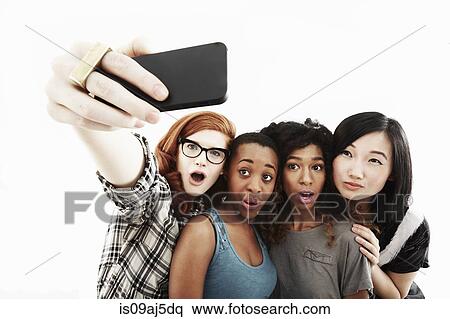Studio portrait of four young women taking selfie on smartphone View Large Photo Image Stock Photography - Studio portrait of four young women taking selfie on smartphone. Fotosearch
