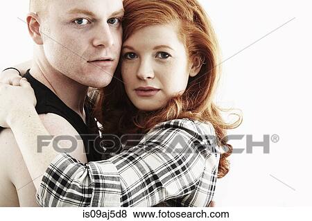 Studio portrait of red haired young couple hugging cheek to cheek View Large Photo Image Stock Photo - Studio portrait of red haired young couple hugging cheek to cheek. Fotosearch