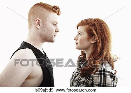 Studio portrait of red haired young couple gazing face to face View Large Photo Image Stock Photo - Studio portrait of red haired young couple gazing face to face. Fotosearch