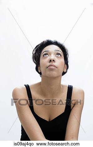 Studio portrait of serene young woman gazing upward View Large Photo Image Picture - Studio portrait of serene young woman gazing upward. Fotosearch