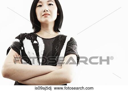 Studio portrait of young woman with arms folded View Large Photo Image Stock Image - Studio portrait of young woman with arms folded. Fotosearch