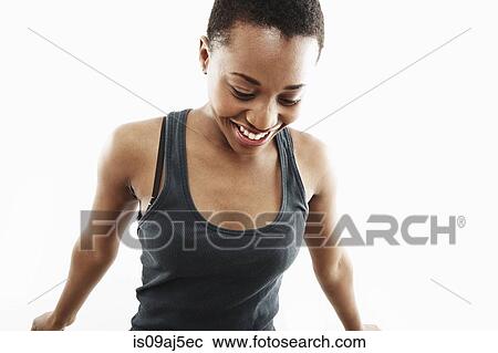 Stock Image - Studio shot of smiling young woman looking down. Fotosearch