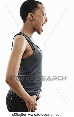 Stock Image - Studio shot of young woman shouting. Fotosearch
