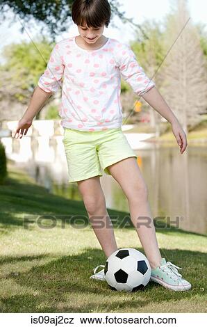 Ten year old girl playing with soccer ball in park View Large Photo Image Stock Photo - Ten year old girl playing with soccer ball in park. Fotosearch