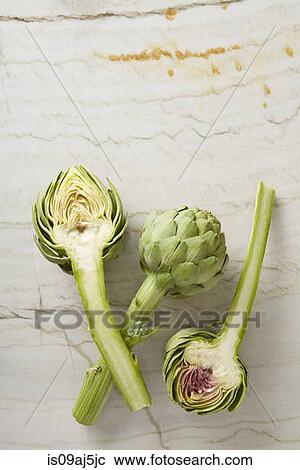 Three fresh sliced globe artichokes on marble surface View Large Photo Image Stock Image - Three fresh sliced globe artichokes on marble surface. Fotosearch