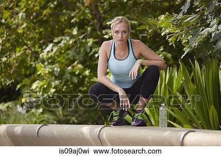 Woman squatting on stone seating View Large Photo Image Stock Image - Woman squatting on stone seating. Fotosearch