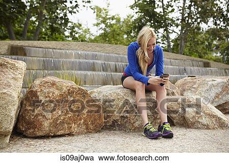 Woman using smartphone on rock View Large Photo Image Stock Image - Woman using smartphone on rock. Fotosearch