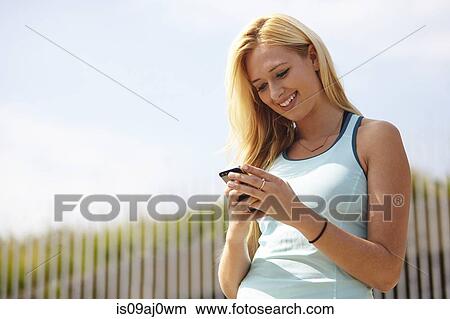 Picture - Woman using smartphone. Fotosearch