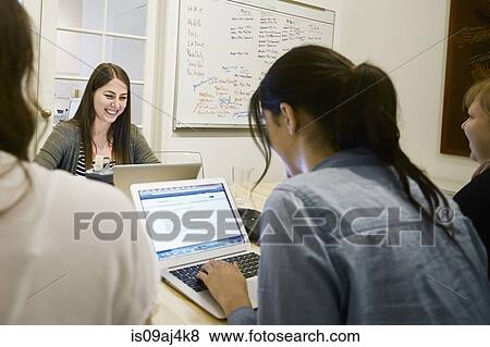 Stock Photo - Women working on laptops in office. Fotosearch