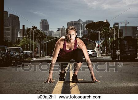 Young adult woman in start position in road, getting ready to run View Large Photo Image Stock Image - Young adult woman in start position in road, getting ready to run. Fotosearch