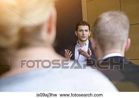 Young businessman speaking to audience in conference room View Large Photo Image Stock Photo - Young businessman speaking to audience in conference room. Fotosearch