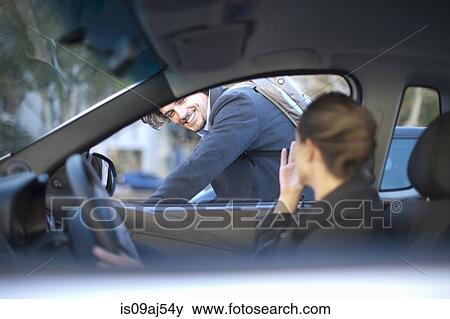 Young businesswoman driving and waving at male cyclist View Large Photo Image Stock Photo - Young businesswoman driving and waving at male cyclist. Fotosearch