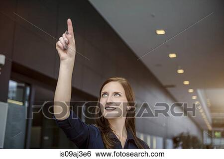 Young businesswoman gesturing with finger in office View Large Photo Image Stock Photograph - Young businesswoman gesturing with finger in office. Fotosearch