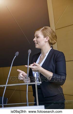 Stock Image - Young businesswoman speaking in conference meeting. Fotosearch