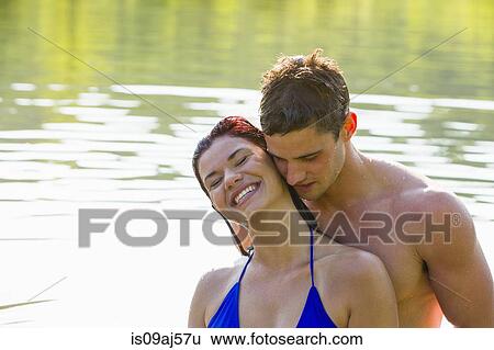 Young couple cheek to cheek in river View Large Photo Image Stock Photograph - Young couple cheek to cheek in river. Fotosearch