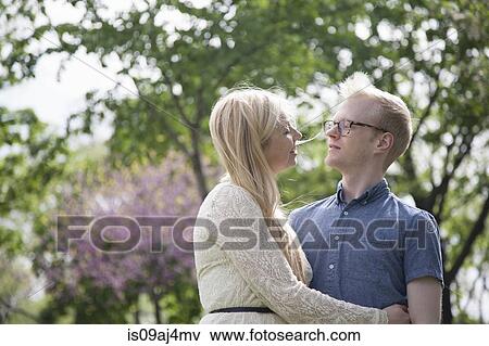 Stock Photo - Young couple embracing in park. Fotosearch