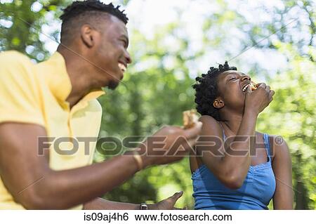 Young couple in park eating sandwiches View Large Photo Image Stock Photograph - Young couple in park eating sandwiches. Fotosearch