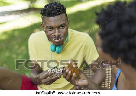Young couple in park picnicing on sandwiches View Large Photo Image Stock Photography - Young couple in park picnicing on sandwiches. Fotosearch