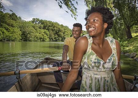 Stock Photograph - Young couple in rowing boat on lake in Central Park, New York City, USA. Fotosearch