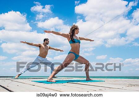 Young couple in warrior pose on pier, San Pedro, Belize View Large Photo Image Stock Image - Young couple in warrior pose on pier, San Pedro, Belize. Fotosearch