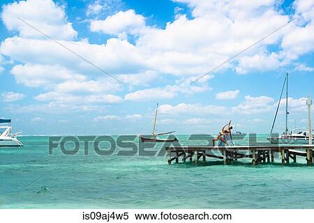 Young couple practising yoga on pier, San Pedro, Belize View Large Photo Image Stock Photography - Young couple practising yoga on pier, San Pedro, Belize. Fotosearch