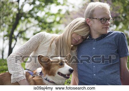 Young couple sitting in park with corgi dog View Large Photo Image Stock Photo - Young couple sitting in park with corgi dog. Fotosearch