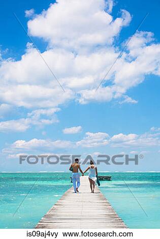 Stock Photo - Young couple walking on pier, San Pedro, Belize. Fotosearch