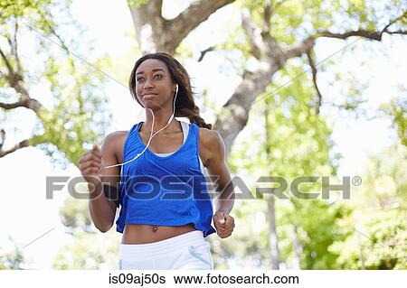 Young female runner running in park View Large Photo Image Stock Photograph - Young female runner running in park. Fotosearch