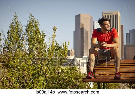 Young male runner taking a break on park bench View Large Photo Image Stock Photography - Young male runner taking a break on park bench. Fotosearch