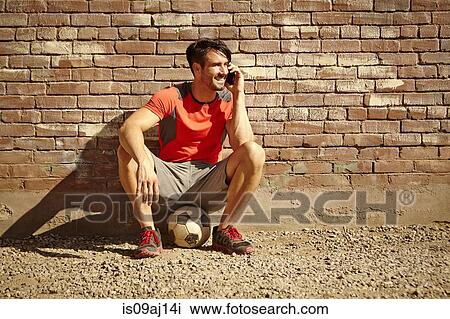 Young male soccer player chatting on smartphone View Large Photo Image Stock Image - Young male soccer player chatting on smartphone. Fotosearch