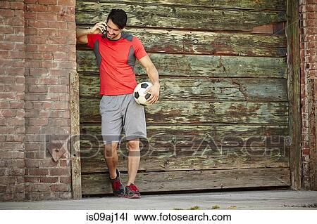 Young male soccer player chatting on smartphone View Large Photo Image Stock Image - Young male soccer player chatting on smartphone. Fotosearch