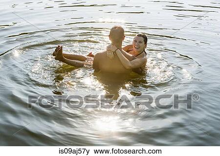 Young man carrying girlfriend in arms in river View Large Photo Image Stock Photo - Young man carrying girlfriend in arms in river. Fotosearch