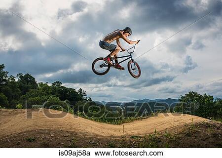 Young man doing BMX trick on rural pump track View Large Photo Image Stock Image - Young man doing BMX trick on rural pump track. Fotosearch