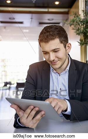 Young man in office using touchscreen on digital tablet View Large Photo Image Stock Image - Young man in office using touchscreen on digital tablet. Fotosearch