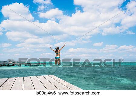 Young woman jumping into ocean, San Pedro, Belize View Large Photo Image Stock Photograph - Young woman jumping into ocean, San Pedro, Belize. Fotosearch