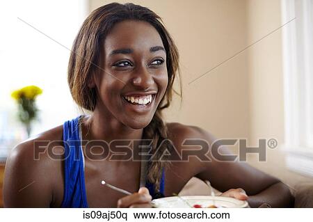 Young woman on a training break, eating fruit in sitting room View Large Photo Image Stock Photography - Young woman on a training break, eating fruit in sitting room. Fotosearch