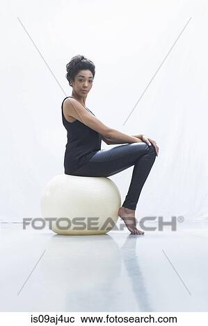 Young woman sitting on fitness ball View Large Photo Image Stock Image - Young woman sitting on fitness ball. Fotosearch