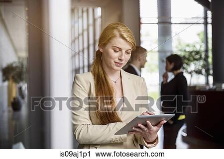 Young woman using touchscreen on digital tablet in office View Large Photo Image Stock Image - Young woman using touchscreen on digital tablet in office. Fotosearch