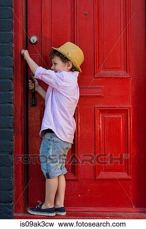 Boy opening red front door View Large Photo Image Stock Photo - Boy opening red front door. Fotosearch