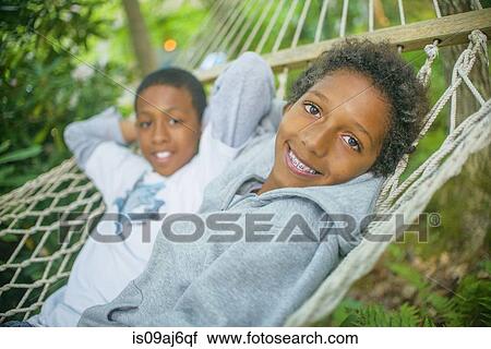 Boys lying in a hammock View Large Photo Image Stock Image - Boys lying in a hammock. Fotosearch