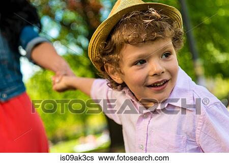Close up of boy holding mother's hand in park View Large Photo Image Stock Photograph - Close up of boy holding mother's hand in park. Fotosearch