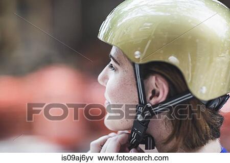 Close up of mid adult woman cyclist fastening cycle helmet View Large Photo Image Stock Photo - Close up of mid adult woman cyclist fastening cycle helmet. Fotosearch
