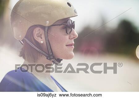 Stock Photo - Close up of mid adult woman cyclist wearing cycle helmet and sunglasses. Fotosearch