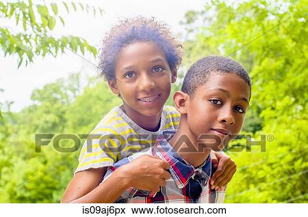 Close up of teenage boy giving friend piggyback ride View Large Photo Image Stock Photo - Close up of teenage boy giving friend piggyback ride. Fotosearch