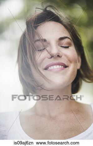 Picture - Close up portrait of smiling mid adult woman with eyes closed. Fotosearch